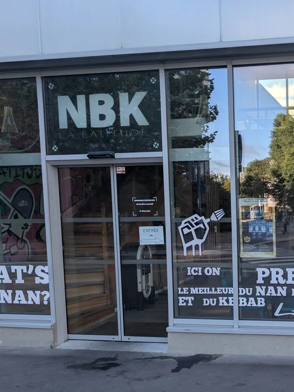 La devanture du NBK Rennes La Courrouze : l’enseigne NBK au-dessus de la porte, et les grandes baies vitrées lettrées « ici on prépare le meilleur du naan, du burger et du kebab »