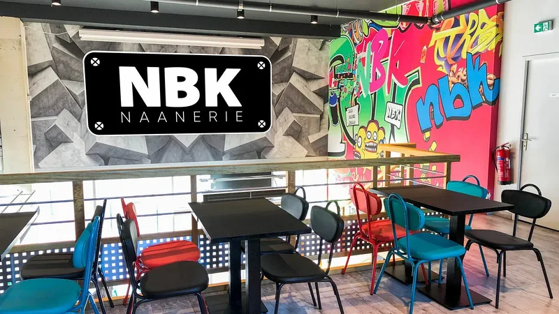 La salle du NBK Rennes La Courrouze : l’enseigne NBK Naanerie au mur, une fresque graffée, des tables et des chaises colorées